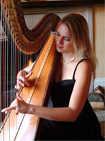 Image of a Harp being played by a blonde harpist
