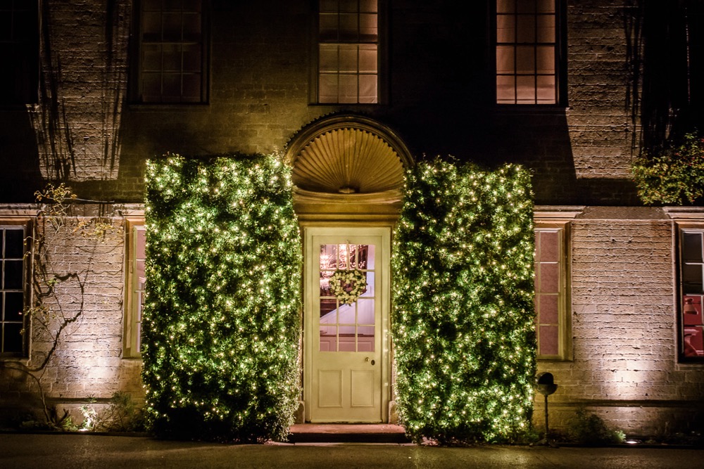 Front of Babington House with bush lighting either side of the front door.