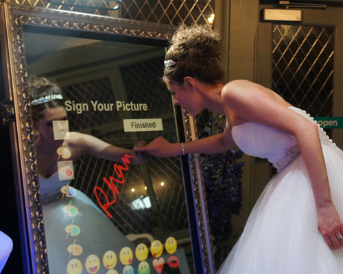image of a bride wiriting ona magic mirror photobooth.