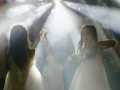 Five bridesmaids dancing in white light.