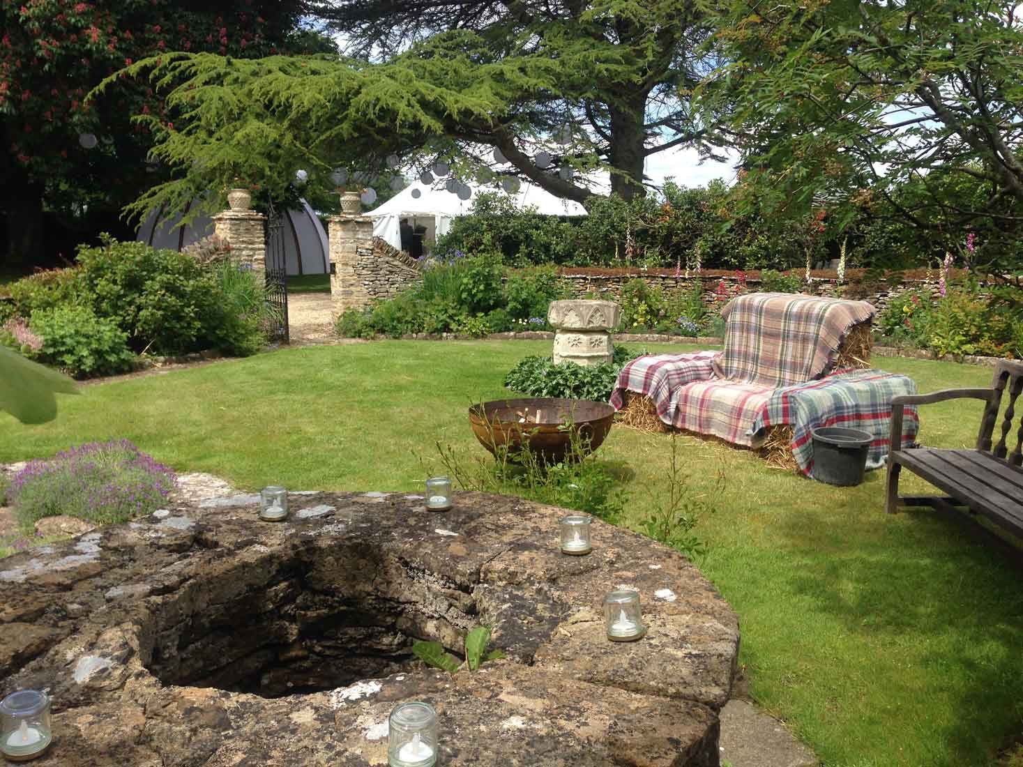 Image of a firepit in a graden with sofa made from hay bales