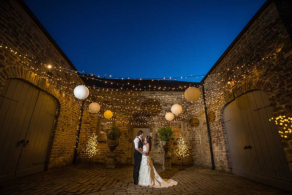 Pennard House in Somerset with a bride and groom at night under a fairy light canopy.